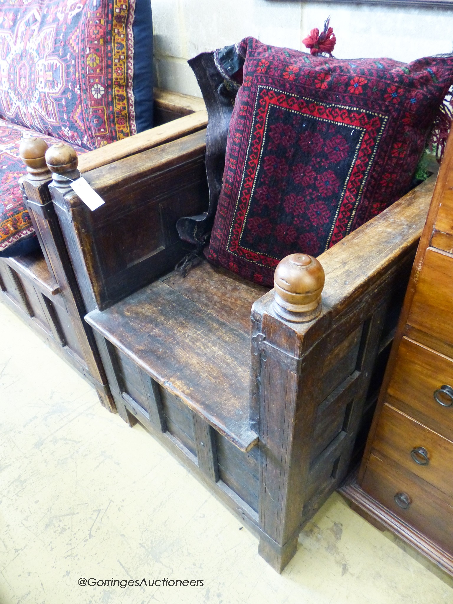 An Indian iron mounted, paneled hardwood hinged box seat bench and two chairs, all with Caucasian/Turkish cushions. Bench - W-138cm, D-69, H-91cm.